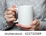 Girl is holding white cup in hands. Mug for woman, gift. Mockup for designs.