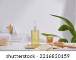 Small photo of Shampoo bottle and cotton towel on a tray, a wooden comb on the side, and a neatly folded towel basket with a green plant in the current bathroom.