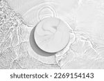 Small photo of White circle podium on transparent clear water texture with splashes and waves in sunlight. Blank space for product promotion