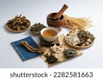 Small photo of A bowl of medicine placed on a wooden podium in the center with many types of herb displayed around. Chinese medicine treat a wide range of ailments to enhance health