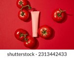 Small photo of Natural skin care concept with a cosmetic container displayed on red background with tomatoes. Many people use Tomato (Solanum lycopersicum) to beautify the skin