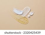 Small photo of Different cosmetic textures of face cream, serum and lotion on beige background. Cosmetics induce a smoother feel and appearance to the skin