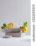 Small photo of Front view of stone podiums with fresh lemon slices. Vacant space to display cosmetic products. Lemon (Citrus limon) is often promoted as a weight loss food