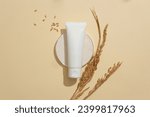 Unbranded cosmetic tube stands out on a minimalist beige background. Creating a vegan cosmetics brand featuring key ingredients sourced from rice bran. Copy space.