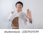 Small photo of Asian Muslim man covers his mouth with his hand and refrains from speaking, the concept of avoiding backbiting while fasting