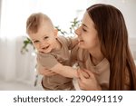 a young beautiful mother with a baby boy hugging on the bed at home in the bedroom, mother's care and love, portrait of a happy mother with a child, healthy motherhood