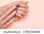 Female hands with pink nail design. Pink nail polish manicured hands. Female hands on pink background