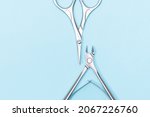 Small photo of Manicure nippers and scissors on blue background. Nails care equipment. Stainless steel nippers and scissors on blue background