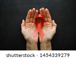 Small photo of Symbol of human immunodeficiency virus disease. Red ribbon. A helping hand and support. Background.