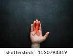 Small photo of Symbol of human immunodeficiency virus disease. Red ribbon. A helping hand and support. Background.