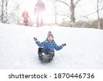 Small photo of Children in the park in winter. Kids play with snow on the playground. They sculpt snowmen and slide down hills.