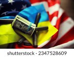 Small photo of American and Ukrainian flags, a pack of American dollars. Aid lend-lease concept.