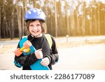 happy child schoolboy hugging his bright plastic city cruiser, skateboard. in the park.