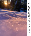 Sun reflecting off snow close up golden hour winter scene blurred purple, orange, and blue reflections located in Belchertown, Massachusetts. Image can be used as background of calendar or other media
