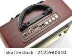 silver buttons control with slot connectors and handle on top of vintage radio, classic design transistor radio receiver with modern control panel on white background, close-up top view