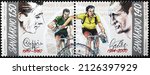 Small photo of Milan, Italy - January 24, 2022: Famous picture of Bartali and Coppi helping eachother on stamp