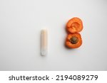 Small photo of Natural lip balms with apricot extract on light white background. Lip balm or lip salve and apricots. The concept of an unnamed lipstick bottle. Commercial idea concept: Lip balm or salve and apricots
