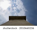 Looking up at one of the pillars of Széchenyi Chain Bridge in Budapest Hungary, with blue sky and white clouds and sunshine in the background