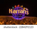 Small photo of Las Vegas, Nevada - March 2017: Sign of the hotel Harrahs glows and flashes at night on the roof of the building. Bright signs of Las Vegas at night. Casino Harrahs flashes bright lights.