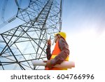 construction worker checking location site near to High voltage tower.