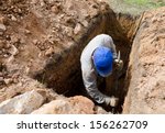 Man In Blue Cap Digs Grave At...