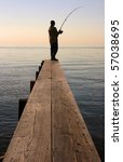 A Fisherman On A Dock In The...