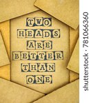 Small photo of Phrase Two Heads Are Better Than One make by black alphabet stamps on cardboard with some piece of cardboard.