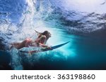 Young girl in bikini - surfer with surf board dive underwater with fun under big ocean wave. Family lifestyle, people water sport lessons and beach swimming activity on summer vacation with child