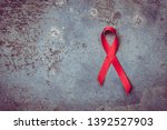 Small photo of Red ribbon symbol of human immunodeficiency virus disease. dark background. aids concept.