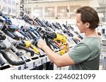 Man shopping drill and perforator in hardware store