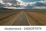 Small photo of The Chuisky Tract road on the background of mountains and sky. Chuisky Tract against the sky of mountains and steppe. The paved Chuysky Tract road. The road in Altai. Landscape road in Altai.