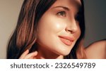 Small photo of Beauty care. Radiant face. Moisturized skin. Cosmetology treatment. Pretty smiling young fresh glowing woman with glossy lip makeup enjoying sunshine isolated on beige.