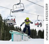 Small photo of Snowboarder in helmet riding snowboard under ski lifts. Man performing tricks with snowboard. Concept of snowboarding and winter extreme sport.