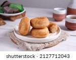 Potato Donuts on a white plate.  Donuts made from donut dough plus steamed potatoes.  Usually served with or without sprinkled with powdered sugar