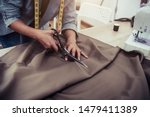 Dressmaker cutting dress fabric on sketch line with sewing machine. Fashion designer tailor or sewer in workshop studio designing new collection clothes. Business owner shop and entrepreneur concept