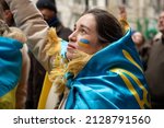Small photo of New York, NY - February 24, 2022: Woman wrapped in Ukrainian flag at a demonstration to protest Putinâ€™s aggression and the invasion of Ukraine