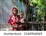Small photo of Gowainghat, Bangladesh – November 06, 2019: A woman becomes an early mother because of early marriage in Bangladesh and child on her lap overcoming the curse of malnutrition in a rural village.