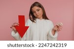 Small photo of Young woman showing golden bitcoins and arrow pointing down, downgrade of electronic currency. Cryptocurrency investment, mining BTC, future technology, network. Caucasian girl on pink background