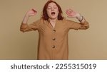 Small photo of Tired redhead woman yawning, sleepy inattentive feeling somnolent lazy bored overworked gaping suffering from lack of sleep. Young exhausted ginger girl isolated alone on beige studio background