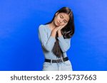 Small photo of Tired exhausted young Caucasian woman sleepy inattentive feeling somnolent lazy bored gaping suffering from lack of sleep, insomnia. Brunette girl isolated on blue studio background indoors