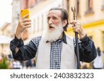 Small photo of Senior elderly man use mobile smartphone celebrating win good message news, lottery jackpot victory, giveaway online outdoors. Happy old grandfather tourist walking in city street. Town lifestyles