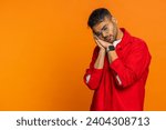 Small photo of Tired exhausted Indian young man, sleepy inattentive feeling somnolent lazy bored gaping suffering from lack of sleep falling asleep. Arabian Hindu guy isolated on orange studio background. Copy-space