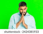 Small photo of Sneaky cunning Indian young man with tricky face gesticulating and scheming evil plan, thinking over devious villain idea, cheats, jokes, pranks. Arabian guy isolated on green chroma key background