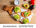 Small photo of Avocado Toast. Open sandwich of toast with mashed avocado, tomatoes, eggs, cheese salt, black pepper, and citrus juice. Fresh avocados smashed into guacamole on toast with vegetables. Classic Lunch.