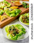 Small photo of Lettuce wraps. Japanese or Thai cuisine entree. Lettuce wraps made with noodles, pork, chicken, tofu, scallions, cilantro, sprouts, limes, jalapenos, peanut sauce. Healthy Asian-style Lettuce wraps.