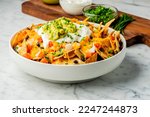 Small photo of Nachos. Crispy tortilla chips topped with melted cheddar cheese, salsa, black beans, jalapenos, guacamole, sour cream and lettuce. Tex-Mex or Mexican restaurant classic traditional menu item.