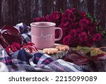 A pink cup of coffee, burgundy asters, autumn grape leaves, cookies and a scarf. Happy autumn mood. Autumn composition on a dark background.