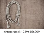Small photo of Rope on the background of baggy, rough fabric