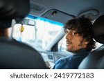 Small photo of Confidence man sitting in the passenger seat of car, turning towards the camera with a compelling expression. Perfect for conveying themes of travel, adventure, and a modern lifestyle.
