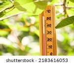 Red heat warning , Heatwave cause climate change and global warming . Thermometer making 30 degrees celsius temperature , extreme hot summer weather in Hungary, Europe. Nature green forest background.
